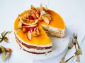 Eine köstliche Pfirsich Maracuja Torte mit frischen Früchten und Sahne. Ein Stück ist bereits angeschnitten.