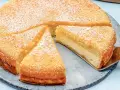 Ein saftiger Käsekuchen, bestäubt mit Puderzucker. Ein Stück wird gerade mit einem Tortenheber herausgehoben. Dreh dich um, Kuchen, du siehst köstlich aus!