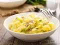 Ein cremiger Kartoffelsalat mit roten Zwiebeln und Schnittlauch, perfekt als Beilage zum Grillen.