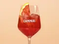 Ein Glas Campari mit Eis und einer Orangenscheibe. Entdecke die Vielfalt der Aperol Spritz Varianten!