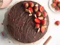 Eine köstliche Erdbeer Yogurette Torte mit Schokoladenglasur, frischen Erdbeeren und kleinen Schokostückchen.