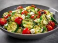Ein köstlicher zucchini salat gebraten mit Kirschtomaten und Feta.