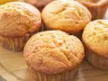 Goldbraune Bananen Quark Muffins auf einem Holzbrett, bereit zum Genießen.