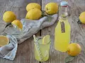 Frische Zitronen und selbstgemachter Zitronensirup in einer Flasche, bereit zum Genießen.