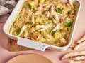 Ein köstlicher Spargel Lachs Auflauf in einer weißen Auflaufform, garniert mit Basilikum. Dazu frischer Spargel.