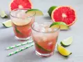 Erfrischender Aperol Paloma mit Grapefruit und Limette, garniert mit frischen Fruchtstücken und Eis.