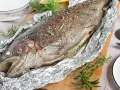 Saftige Lachsforelle im Backofen, mit Kräutern und Gewürzen verfeinert, bereit zum Servieren.