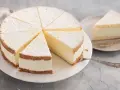 Leichter Biskuitkuchen mit cremiger Füllung, bestäubt mit Puderzucker. Neue Kuchen Rezepte zum Nachbacken.