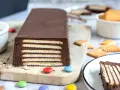 Schokoladiger Kalter Hund, Omas Rezept, geschichtet mit Keksen und Schokocreme, verziert mit bunten Smarties.