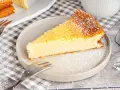 Ein saftiges Stück Kokoskuchen mit Pudding, gebacken in einer Springform, bestäubt mit Puderzucker.