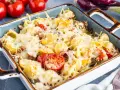 Herzhafter Nudel Thunfisch Auflauf mit geschmolzenem Käse, Tomaten und Zwiebeln, bereit zum Servieren.