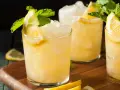 Erfrischender French 75 mit Zitrone und Minze, serviert auf Eis.