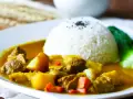 Ein Teller mit Reis und einem herzhaften Curry, das an seine Ursprünge in Indien erinnert.
