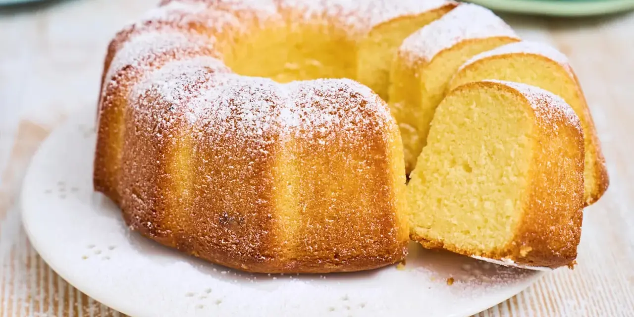 Ein goldbrauner Gugelhupf, bestäubt mit Puderzucker. Dieser Kuchen mit vielen Eiern duftet herrlich und ist bereit zum Genießen.