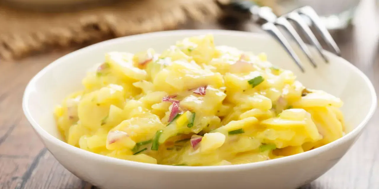 Ein cremiger Kartoffelsalat mit roten Zwiebeln und Schnittlauch, perfekt als Beilage zum Grillen.
