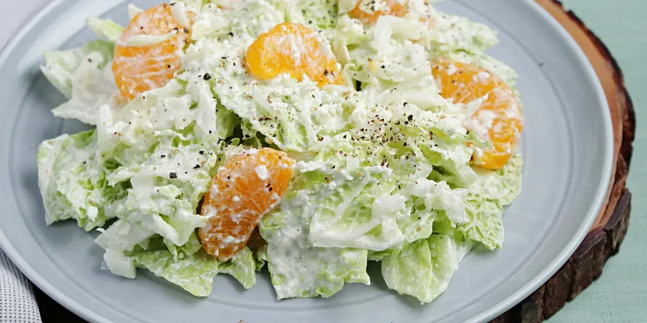 Frischer Chinakohlsalat mit saftigen Mandarinenstücken, cremig angemacht und mit Pfeffer bestreut. Ein leichter Genuss!