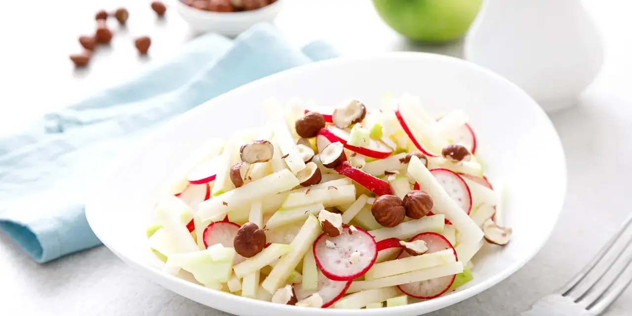 Frischer Kohlrabi-Apfel-Salat mit Radieschen und Haselnüssen, ein leichter Genuss.