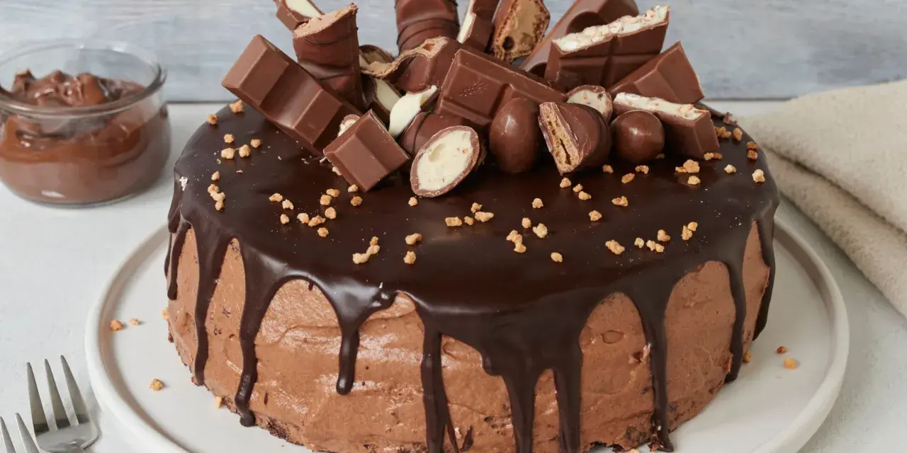 Schokoladentraum: Ein Kuchen, der Lust aufs Backen mit Nutella macht, dekoriert mit vielen Schokoriegeln und Pralinen.