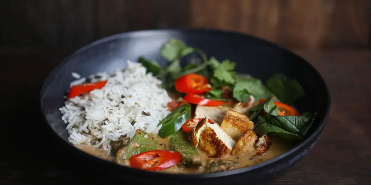 Ein köstliches Curry mit Reis, Tofu, Chilis und frischen Kräutern. Perfekt, um Curry selber machen zu lernen.