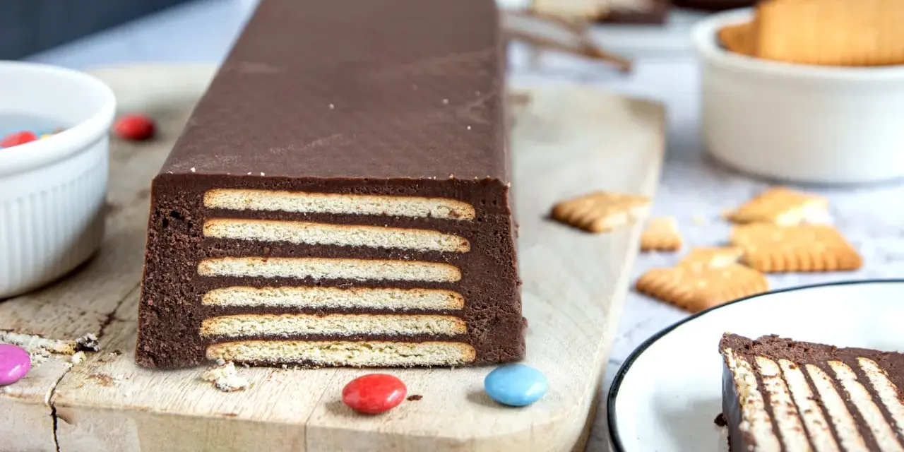 Schokoladiger Kalter Hund, Omas Rezept, geschichtet mit Keksen und Schokocreme, verziert mit bunten Smarties.