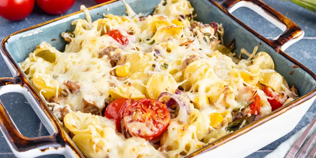Herzhafter Nudel Thunfisch Auflauf mit geschmolzenem Käse, Tomaten und Zwiebeln, bereit zum Servieren.
