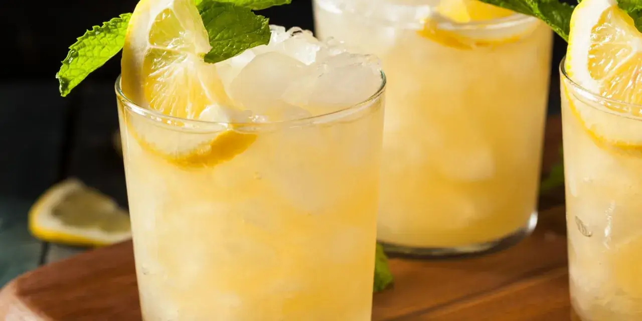 Erfrischender French 75 mit Zitrone und Minze, serviert auf Eis.