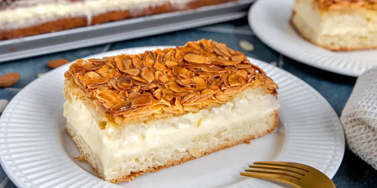 Ein Stück Bienenstich ohne Hefe mit cremiger Füllung und karamellisierten Mandeln. Ein köstliches Rezept für jeden Anlass.