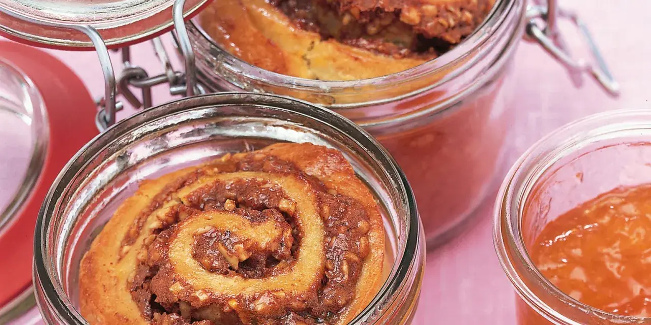 Zwei Gläser mit leckerem Kuchen im Glas, gefüllt mit Zimt-Nuss-Füllung und Marmelade.