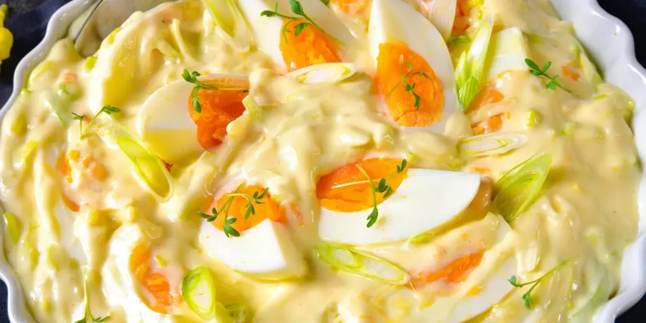 Cremiger Eiersalat mit Lauchzwiebeln und Kräutern, serviert in einer weißen Schüssel. Ein köstlicher Salat, der perfekt zu vielen Gerichten passt.