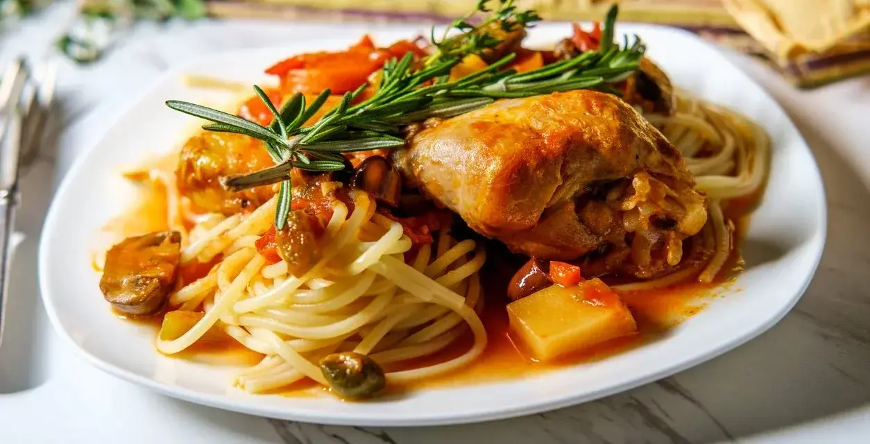 Deftig pollo alla cacciatora mit Spaghetti, garniert mit Rosmarin.