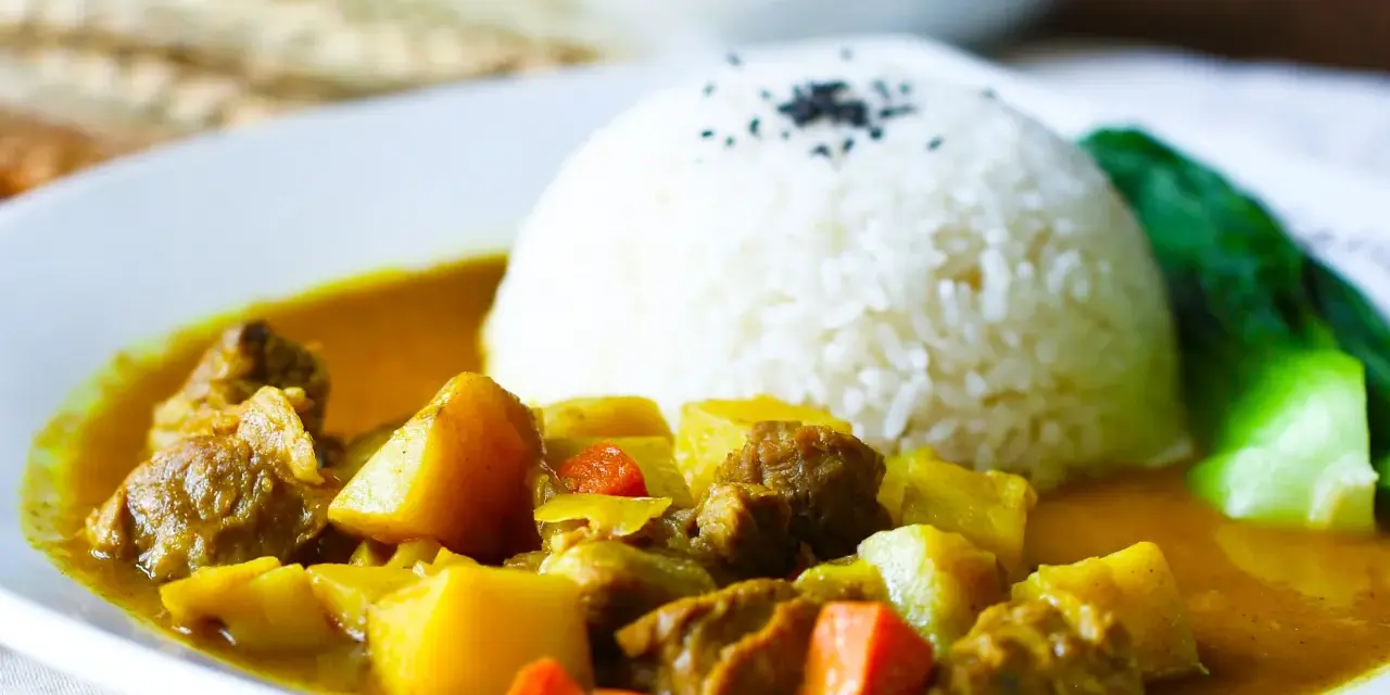 Ein Teller mit Reis und einem herzhaften Curry, das an seine Ursprünge in Indien erinnert.