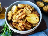 Schmackhafte Kartoffelscheiben mit Rosmarin, perfekt gegrillt. Die Streifen vom Grill sind deutlich sichtbar.