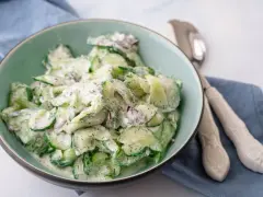 Frischer gurkensalat mit saurer sahne, Dill und roten Zwiebeln in einer Schüssel, bereit zum Servieren.