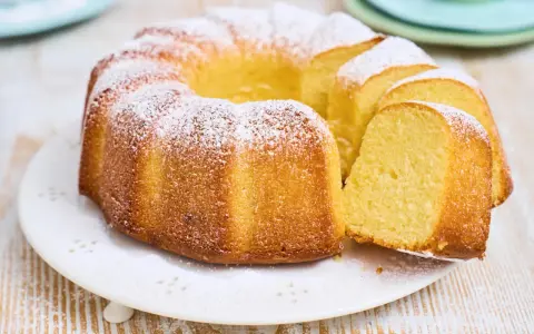 Ein goldbrauner Gugelhupf, bestäubt mit Puderzucker. Dieser Kuchen mit vielen Eiern duftet herrlich und ist bereit zum Genießen.