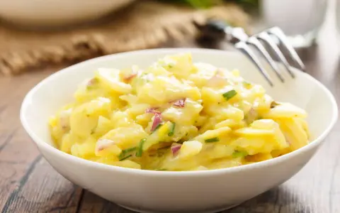 Ein cremiger Kartoffelsalat mit roten Zwiebeln und Schnittlauch, perfekt als Beilage zum Grillen.