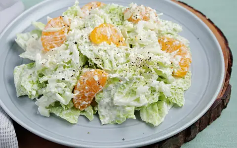 Frischer Chinakohlsalat mit saftigen Mandarinenstücken, cremig angemacht und mit Pfeffer bestreut. Ein leichter Genuss!