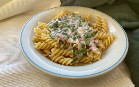 Fusilli-Pasta mit einer cremigen Sauce aus Erbsen und Speck, ein klassisches italienisches Gericht.