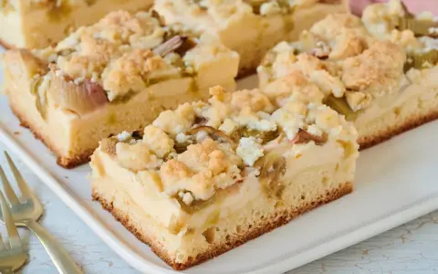Saftiger Rhabarberkuchen mit Pudding vom Blech, bestreut mit knusprigen Streuseln. Ein Genuss für jeden Kaffeetisch!