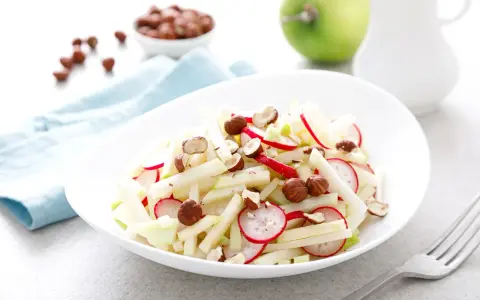 Frischer Kohlrabi-Apfel-Salat mit Radieschen und Haselnüssen, ein leichter Genuss.