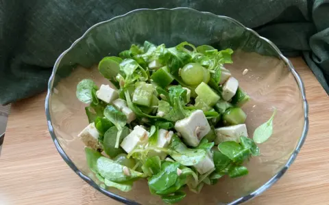 Erfrischender Salat mit grünen Weintrauben, Feta und Gurke in einer Glasschüssel.