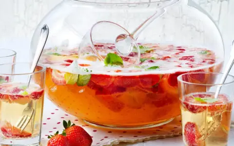 Erfrischendes Bowle-Rezept mit Erdbeeren und Minze in einer großen Glasbowle, bereit zum Servieren in Gläsern.