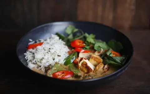 Ein köstliches Curry mit Reis, Tofu, Chilis und frischen Kräutern. Perfekt, um Curry selber machen zu lernen.