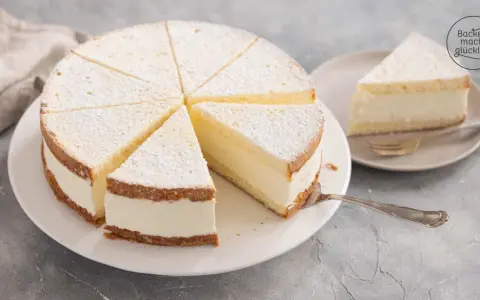 Leichter Biskuitkuchen mit cremiger Füllung, bestäubt mit Puderzucker. Neue Kuchen Rezepte zum Nachbacken.