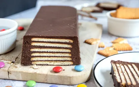 Schokoladiger Kalter Hund, Omas Rezept, geschichtet mit Keksen und Schokocreme, verziert mit bunten Smarties.