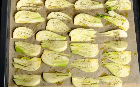 Vorbereiteter Fenchel für den Ofen, mit Olivenöl und Kräutern gewürzt, bereit für ein italienisches Gericht.