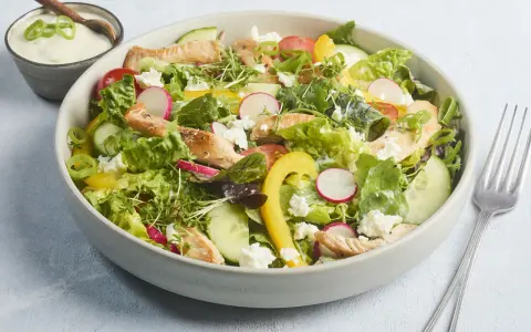 Frischer Salat mit Putenstreifen, Gurken, Radieschen, Tomaten, gelber Paprika und Feta. Dazu ein cremiges Dressing.