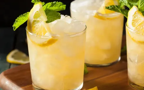 Erfrischender French 75 mit Zitrone und Minze, serviert auf Eis.