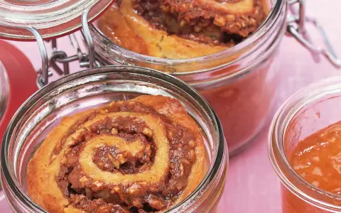 Zwei Gläser mit leckerem Kuchen im Glas, gefüllt mit Zimt-Nuss-Füllung und Marmelade.