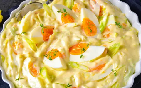 Cremiger Eiersalat mit Lauchzwiebeln und Kräutern, serviert in einer weißen Schüssel. Ein köstlicher Salat, der perfekt zu vielen Gerichten passt.
