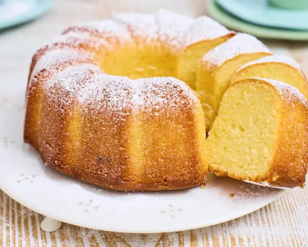 Ein goldbrauner Gugelhupf, bestäubt mit Puderzucker. Dieser Kuchen mit vielen Eiern duftet herrlich und ist bereit zum Genießen.
